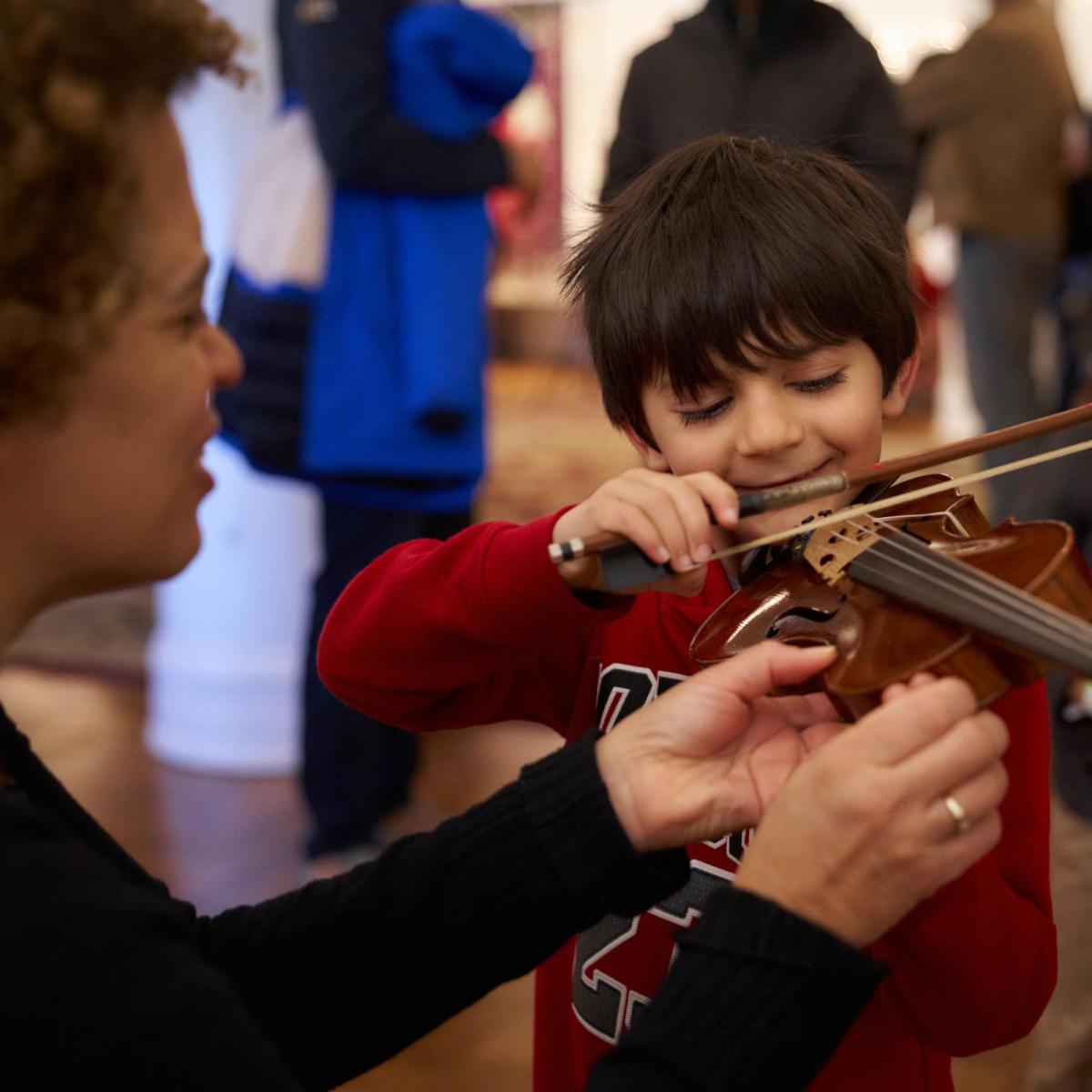 Music Institute of Chicago Teacher with young boy trying violin for the first time