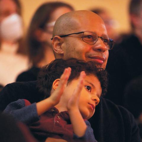 Adult with child in audience at Nichols Concert Hall